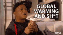 a man holding a cup of coffee with the words global warming and sh * t