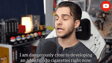 a man is talking into a microphone and says i am dangerously close to develop an addiction to cigarettes right now