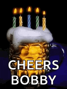 a mug of beer with candles on top of it and the words cheers bobby