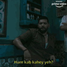 a man is sitting in a dark room with the words hum kab kahey yeh written above him