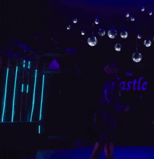 a man is walking in a dark room with purple lights