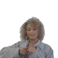 a woman with curly hair is wearing a grey jacket and a chain around her neck
