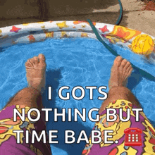 a person is sitting in a pool with their feet in the water and says `` i gots nothing but time babe '' .